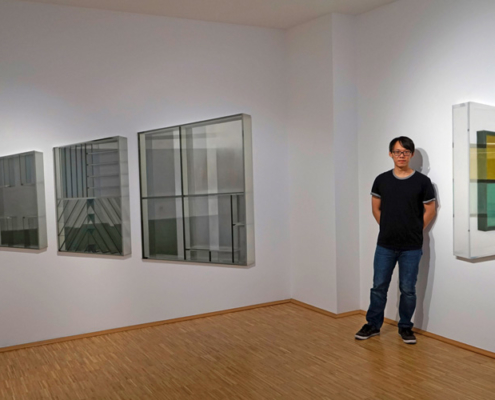Chao-Kang Chung in der Galerie mit seinen Werken „Wenn die großen Meister keine Farben hätten“ (links) und „No Windows“ (rechts)