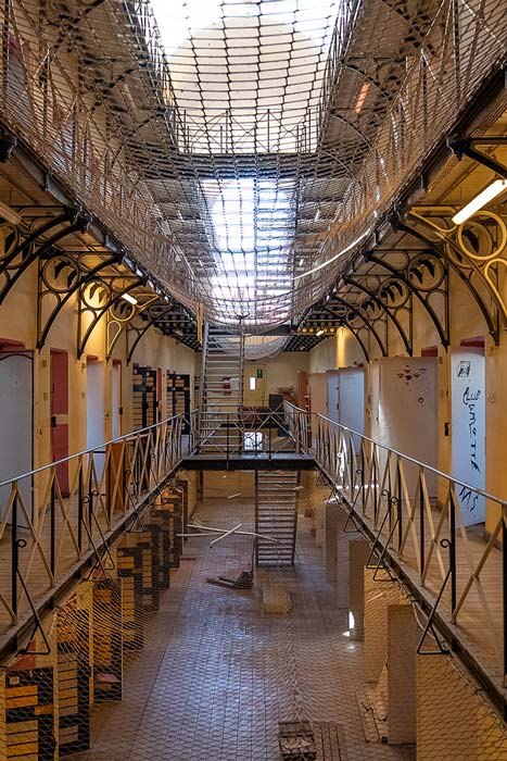 03.10.–15.11.26<br> Stadtmuseum: Gefängnisarchitektur »Jenseits der Mauern« Innenansicht der alten Justizvollzugsanstalt Münster mit Zellentüren, umlaufenden Galerien und vergitterter Dachkonstruktion, fotografiert von Chris Schwemmer