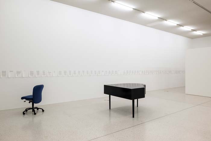 17.10.26–17.01.27<br> Westfälischer Kunstverein: Sanna Helena Berger Installationsansicht „Œuvre (working title)“ von Sanna Helena Berger im Westfälischen Kunstverein: Ein schwarzer Tisch und ein blauer Bürostuhl stehen in einem hellen Ausstellungsraum. An den weißen Wänden hängen zahlreiche kleinformatige Blätter in einer langen Reihe.