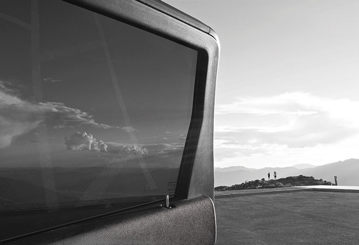 20.09.–06.12.26<br>LAER | Galerie Lengershaus: Fotografien von Aleš Sobota Schwarz-Weiß-Fotografie von Aleš Sobota mit dem Fenster und der Karosserie eines Fahrzeugs im Vordergrund sowie einer weiten Landschaft mit vereinzelten Personen am Horizont